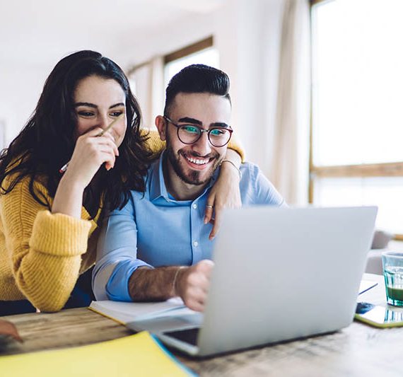 Happy Couple Looking At Computer